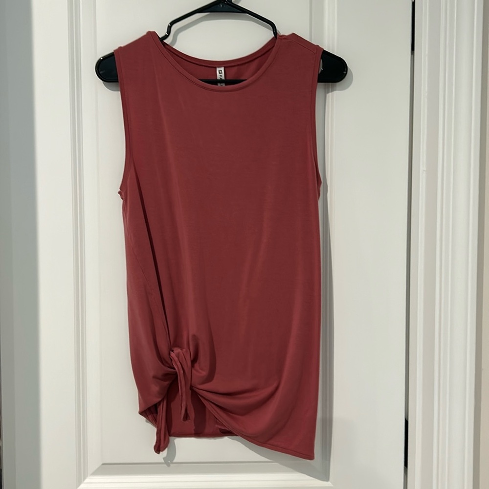 Fabletics salmon colored sleeveless jersey top with tie on the side.